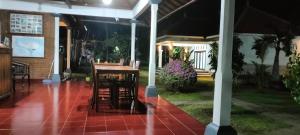 a house with a table and chairs on a patio at Bayumantra Bungalows in Lovina