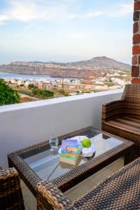 uma mesa e cadeiras numa varanda com vista em Anya Suites Santorini em Acrotíri