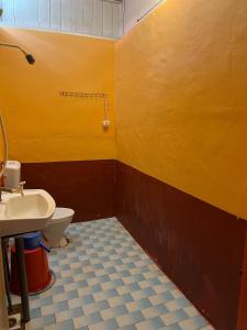 uma casa de banho amarela com um WC e um lavatório em MUKUT CORAL CHALET em Ilha Tioman
