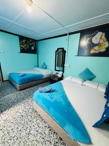 a bedroom with two beds and a tv in it at MUKUT CORAL CHALET in Tioman Island