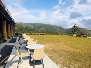 a row of tables and chairs on a patio with a field at Fusen Purifying in Toucheng
