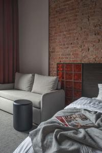 salon z kanapą i ceglaną ścianą w obiekcie Resume apartments, Dreamer Corner No1 by Urban Rent w Kownie