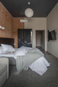 a bedroom with a large bed and a couch at Resume apartments, Dreamer Corner No1 by Urban Rent in Kaunas