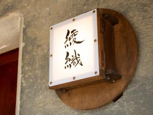 a box with writing on it on a wall at がもう家 明治時代の蔵に泊まれる一棟貸し宿 Ancient renovated house in the Japanese Countryside with a kindly hospitality in Sakaide