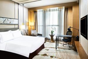 ein Hotelzimmer mit einem Bett und einem Schreibtisch in der Unterkunft Crowne Plaza Tianjin Meijiangnan, an IHG Hotel in Tianjin