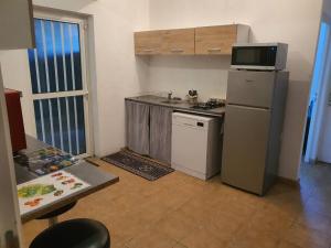 a small kitchen with a refrigerator and a microwave at Villa Kaz A Nou in Les Avirons +6 photos