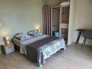 a bedroom with a bed with two pillows on it at Villa Kaz A Nou in Les Avirons