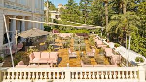 Un balcón con sillas y mesas en un patio en Hotel Les Tourelles, en Sainte-Maxime