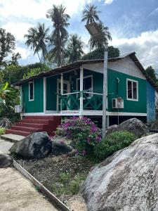 ein grünes Haus mit einer Kamera davor in der Unterkunft MUKUT CORAL CHALET in Tioman Island