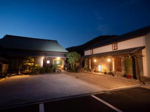 坂出市がもう家 明治時代の蔵に泊まれる一棟貸し宿 Ancient renovated house in the Japanese Countryside with a kindly hospitality的夜间大楼前的一个空停车位
