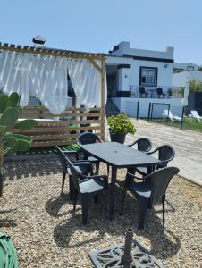 een patio met een tafel en stoelen en een hek bij LA BRISA in Cádiz