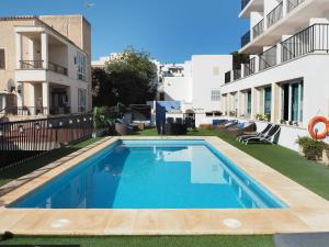 a swimming pool in the backyard of a building at Hotel Rocamar in Cala Figuera