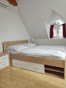 a bedroom with a bed and a window at Katerina Vendégház in Tihany