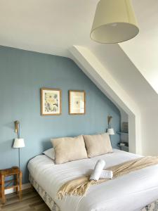 a bedroom with a white bed with blue walls at La Maison Bucolique, Centre de Saint Jacques in Saint-Jacques-de-la-Lande