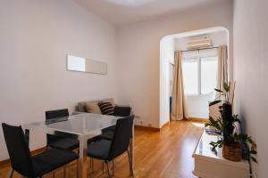 een woonkamer met een tafel en stoelen en een bank bij Cute Apartment in Barcelona