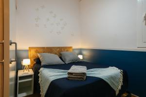 een slaapkamer met een blauw bed en een blauwe muur bij Cute Apartment in Barcelona