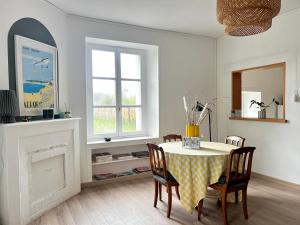 a dining room with a table and a fireplace at La Maison Bucolique, Centre de Saint Jacques in Saint-Jacques-de-la-Lande +8 photos