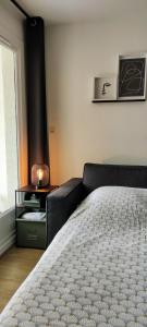 a bedroom with a bed and a table with a lamp at Appart Cosy Green, Océan, Golf, Piscine, Wifi in Moliets-et-Maa