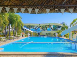 a large swimming pool in a resort with palm trees at Fiesta Garden Hotel by SMS Hospitality in Vigan