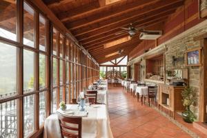 - une salle à manger avec des tables, des chaises et des fenêtres dans l'établissement Hotel & Spa Etxegana, à Zeanuri