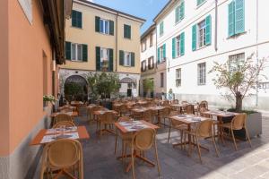 an outdoor patio with tables and chairs and buildings at Avenue Boutique Hotel in Como