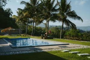 a swimming pool with palm trees in the background at Morika Villa in Rua