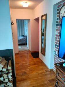 a hallway with a clock on the wall and a mirror at Hiiumaa Family Apartments Kõrgessaare in Kõrgessaare +11 photos