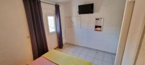 a room with a bed and a television on a wall at Villa Ana in Slatine