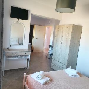a room with a bed and a dresser and a mirror at Pefki Apartment 8 in Artemísion