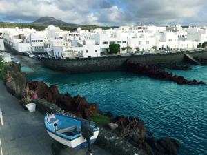 a small boat in the water in front of buildings at Casa Costa Jameos in Punta de Mujeres