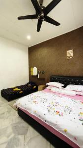 - une chambre avec un lit et un ventilateur de plafond dans l'établissement PD Best Homestay, à Port Dickson