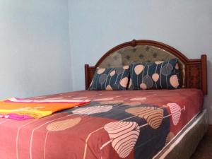 a bedroom with a bed with a bedspread on it at Sawe Homestay in Kuta Lombok