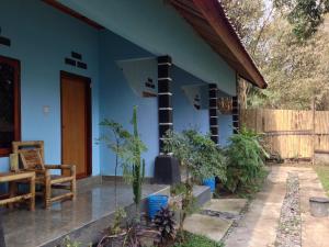 a blue house with a chair and some plants at Sawe Homestay in Kuta Lombok