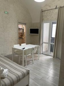 ein weißes Esszimmer mit einem Tisch und Stühlen in der Unterkunft Vittorio Emanuele house in Catania