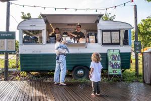 a group of people standing in front of a food truck at Huttopia Calvados - Normandie in Moyaux +20 photos