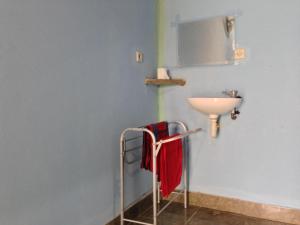 a bathroom with a sink and a towel rack at Sawe Homestay in Kuta Lombok