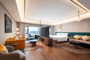 une chambre d'hôtel avec un lit et une télévision dans l'établissement Hilton Garden Inn Beijing West Railway Station, à Pékin