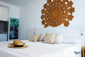 a bed with a hat and pillows on it at Marina Playa Hotel Apartments by Typic Hotels - Adults Only in San Antonio Bay +69 photos