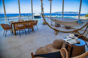 a balcony with a hammock and a table and a boat at Lalaros Apartment in Glossa