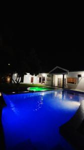 - une piscine éclairée la nuit avec des lumières bleues dans l'établissement PD Best Homestay, à Port Dickson