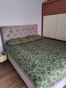 克寧的住宿－Studio apartman，一间卧室配有一张带绿色棉被的床