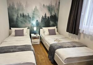 2 camas individuales en una habitación con una pintura en la pared en Pod kamieniem, en Trzebiel