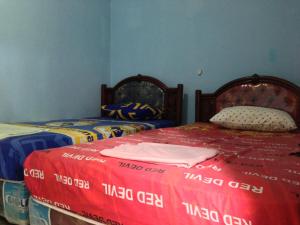 a bedroom with two twin beds at Sawe Homestay in Kuta Lombok