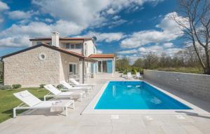 a swimming pool with lounge chairs and a house at Villa Paulina by SeeAdria Agency in Buje