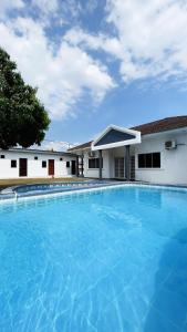 a large blue swimming pool in front of two buildings at PD Best Homestay in Port Dickson