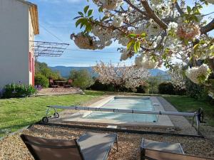 una piscina in un cortile con due sedie di Le Petit Mas des Hauts de Beyssan, Maison de vacances avec piscine privative pour 2 personnes a Gargas