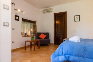 ein Schlafzimmer mit einem blauen Bett und einem Stuhl in der Unterkunft Il Mosaico - Bilocale - 1 camera da letto - 1 bagno - soggiorno cucina - in zona esclusiva in Castellammare di Velia