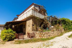 ein altes Steinhaus an der Seite einer unbefestigten Straße in der Unterkunft Il Mosaico - Bilocale - 1 camera da letto - 1 bagno - soggiorno cucina - in zona esclusiva in Castellammare di Velia