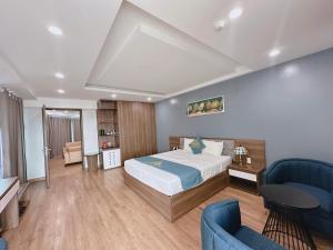 1 dormitorio con 1 cama y 2 sillas azules en Queen Hotel Hoàng Gia, en Thái Nguyên