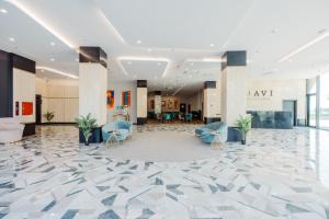 a lobby of a building with blue chairs at Apart Hotel NAVI in Batumi
